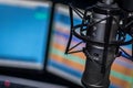 Closeup of a studio Microphone with computers in a background Royalty Free Stock Photo