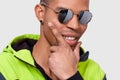 Closeup studio portrait of African American man smiling and posing for advertisement wearing trendy mirror sunglasses, isolated on Royalty Free Stock Photo