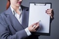 Closeup studio portrait, business woman in a gray business suit, jacket. holding in his hand a folder with a blank sheet, a pencil Royalty Free Stock Photo