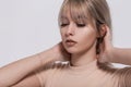 Closeup studio portrait of a female face with clean healthy skin with sexy lips. Attractive young blonde woman straightens hair