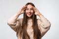 Closeup portrait of Young beautiful brunette woman looking through her fingers like binoculars, searching for something Royalty Free Stock Photo