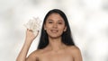 Closeup studio shot of attractive young model. Beautiful asian girl with long hair and natural makeup holding flowers Royalty Free Stock Photo