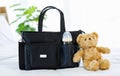 Closeup studio shot of black color multifunction multipurpose utility newborn toddler accessories handbag with milk baby bottle in