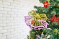 Closeup studio shot of decorative gold pink plastic bells ornamental bauble hanging on Christmas pine tree branch celebrating Xmas Royalty Free Stock Photo