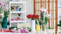 Closeup studio shot fresh red and pink petal roses bunch bouquet in white ceramic vase placed on workshop table with other Royalty Free Stock Photo