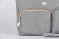 Closeup studio shot of gray color multifunction multipurpose utility zipper newborn baby toddler mommy handbag with milk bottle