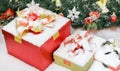 Closeup studio shot of Red paper wrapped present gift boxes with gold ribbon bowtie covered by white snow placed on wood table Royalty Free Stock Photo