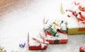 Closeup studio shot of Red paper wrapped present gift boxes with gold ribbon bowtie covered by white snow placed on wood table Royalty Free Stock Photo