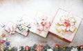 Closeup studio shot of Red paper wrapped present gift boxes with gold ribbon bowtie covered by white snow placed on wood table Royalty Free Stock Photo