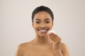 Closeup of smiling pretty young black woman using cotton pad Royalty Free Stock Photo