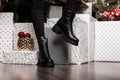 Closeup of stylish black winter boots on female legs indoors. Young woman in fashionable boots in black jeans poses near beautiful Royalty Free Stock Photo