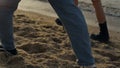 Couple feet walking on sandy beach. Girl and guy legs going along ocean shore Royalty Free Stock Photo