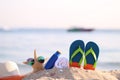 Closeup of Summer beach with accessories of blue flip flops, hat, sun protection cream, towel and sunglasses on starfish in Royalty Free Stock Photo