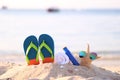 Closeup of Summer beach with accessories of blue flip flops, sun protection cream, towel and sunglasses on starfish in tropical Royalty Free Stock Photo