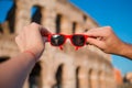 Closeup sunglasses in hands in front of Colosseum in Rome, Italy Royalty Free Stock Photo