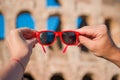 Closeup sunglasses in hands in front of Colosseum in Rome, Italy Royalty Free Stock Photo