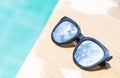 Closeup sunglasses with sky reflection on swimming pool edge with space on blue water background Royalty Free Stock Photo