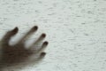 Closeup surface shadow of hand behind gray fabric curtain textured background with copy space in horror concept Royalty Free Stock Photo