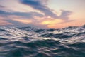 Closeup surface of wavy ocean blue sea water with sunset and red clouds behind. Abstract Background Texture. Royalty Free Stock Photo