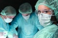 Closeup of surgeons performing operation. Focus on female nurse. Medicine, surgery and emergency help concepts