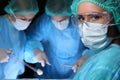 Closeup of surgeons performing operation. Focus on female nurse. Medicine, surgery and emergency help concepts