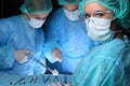Closeup of surgeons performing operation. Focus on female nurse. Medicine, surgery and emergency help concepts Royalty Free Stock Photo