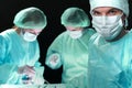 Closeup of surgeons performing operation. Focus on male doctor. Medicine, surgery and emergency help concepts Royalty Free Stock Photo