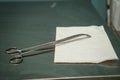 Closeup of a surgical scissor on a paper towel on the table under the lights Royalty Free Stock Photo