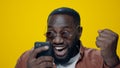 Closeup surprised african man celebrating victory on yellow background. Royalty Free Stock Photo