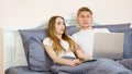 Closeup Surprised emotional white Lover or couple when using technology laptop on the bed in bed room at modern home, couple