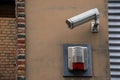 Closeup of a surveillance camera on a beige wall of a brick building Royalty Free Stock Photo