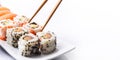 Closeup of sushi roll dish with bamboo chopstick frame isolated on white background. Luxury japanese restaurant dinner with Royalty Free Stock Photo