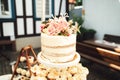 Closeup of sweet round cake with floral decoration on top of multi-tiered dessert stand. Celebration, party, birthday or Royalty Free Stock Photo