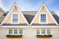 closeup of symmetrical dormers on a cape cod with contrasting shutters