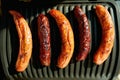 Closeup on table with electric grill and grilled sausages Royalty Free Stock Photo