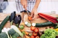 Closeup of table full of vegetables like tomatoes, carrots and more - adult or senior cutting food inthe kitchen at home or