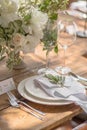 Closeup of a table setting with rustic-style flowers for guests at a wedding or birthday party Royalty Free Stock Photo