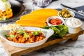 Closeup of tacos chicken tortillas and platter Mexican on a wooden board, blurred background