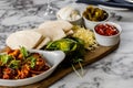 Closeup of tacos chicken tortillas and platter Mexican on a wooden board, blurred background