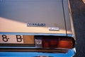 Closeup of tail lights, plat numbers and logo of an old Austin Victoria De Luxe car in cream color