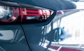 Closeup taillight of gray car parked in luxury showroom. New car parked in modern showroom. Automobile leasing and insurance Royalty Free Stock Photo