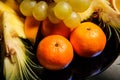 Closeup tangerines and assorted tropical fruits on big plate Royalty Free Stock Photo