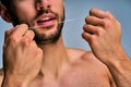 Closeup tanned male hands with white dental floss. Dental concept