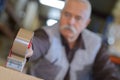 Closeup tape dispenser being used by senior man