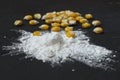 Closeup of tapioca starch or powder flour with maize grains on a black background. Corn starch with yellow grains on a Royalty Free Stock Photo