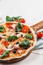 .CLOSEUP Tasty Italian Hot Pizza on white wooden table with mushrooms, basil, tomato, olives and cheese. Look as Prosciutto, Royalty Free Stock Photo