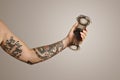 Closeup of tattooed man`s hand holding aeropress