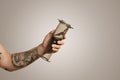 Closeup of tattooed man`s hand holding aeropress