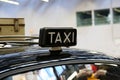 Closeup of a taxi sign on the roof of a black vehicle