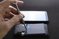 Technician tightening screws on disassembled smartphone during repair Royalty Free Stock Photo